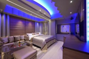 een slaapkamer met een bed, een bank en een tv bij Hotel Pasadena レジャーホテル in Nagoya