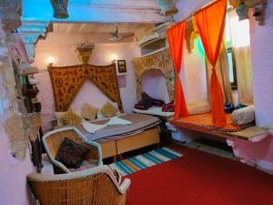 a room with two beds and two chairs in it at Shiva Guest House in Jaisalmer