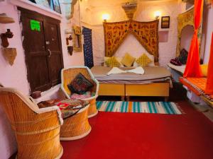 a room with a bed and chairs in a room at Shiva Guest House in Jaisalmer