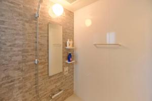 ducha con puerta de cristal y espejo en Modello Sangenjaya, en Tokio