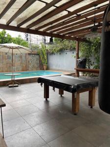 a ping pong table on a patio next to a swimming pool at Casa em Freguesia (Jacarepaguá) in Rio de Janeiro