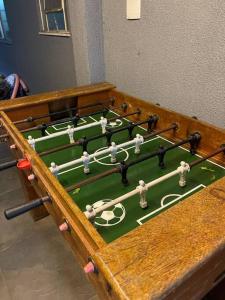 a wooden table with a green foosball table withulators at Casa em Freguesia (Jacarepaguá) in Rio de Janeiro