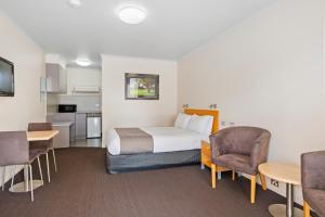 a hotel room with a bed and a table and chairs at Comfort Inn Clubarham in Barham