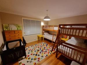 Zimmer mit 2 Etagenbetten und einem Teppich in der Unterkunft Two Pines, whole home in Tullamarine near airport! in Melbourne