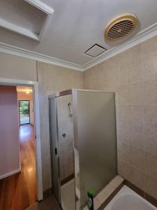 a bathroom with a shower and a toilet in a room at Two Pines, whole home in Tullamarine near airport! in Melbourne