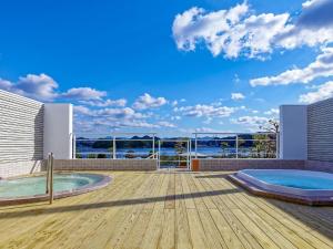 una casa con 2 bañeras de hidromasaje en una terraza en Yukai Resort Premium Shirahama Saichoraku, en Shirahama
