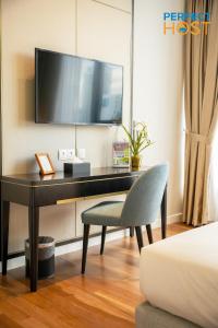 a desk with a chair and a television on a wall at Pavilion Ceylon Hill Suites, Bukit Bintang in Kuala Lumpur