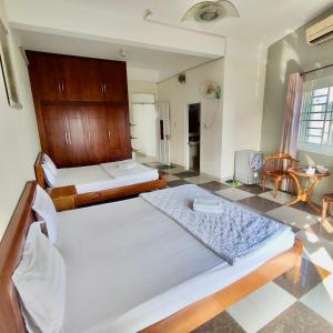 um quarto com 2 camas e uma cozinha com uma mesa em Hoàng Nam - 617 Nguyễn Thị Định, Q2 - by Bay Hostel em Ho Chi Minh