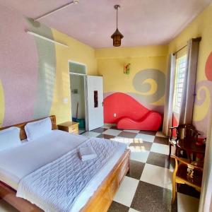- une chambre avec un grand lit et un sol en damier dans l'établissement Hoàng Nam - 617 Nguyễn Thị Định, Q2 - by Bay Hostel, à Hô-Chi-Minh-Ville