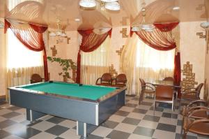 a pool table in a room with tables and chairs at Hotel Complex Dobriy Finn in Kazan