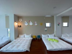羅東鎮的住宿－羅東暖居，配有白色床单的客房内的两张床