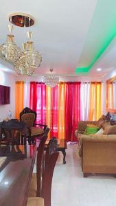 sala de estar con cortinas coloridas y sofá en Cómodo apartamento en Santiago, en Licey al Medio