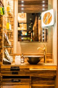 a bathroom with a bowl sink and a mirror at Petit Bali Forest Shinjuku Sanchōme in Tokyo