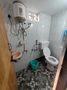 a small bathroom with a toilet and a sink at KENSON HOMESTAY in Mangalore