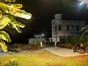 a motorcycle parked in front of a building at night at KENSON HOMESTAY in Mangalore