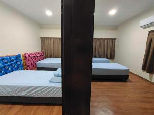 a room with two beds and two chairs at clp perai homestay near Sri Muniswarar Temple 2 in Perai