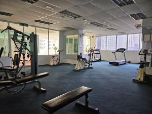 - une salle de sport avec plusieurs tapis de course et des vélos d'exercice dans l'établissement Downtown Chill, à Kuala Lumpur