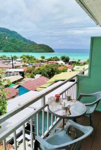 a table on a balcony with a view of the ocean at Blue View House Phi Phi in Phi Phi Islands