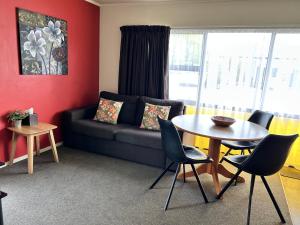 uma sala de estar com um sofá e uma mesa em Arcadia Motel em Nelson