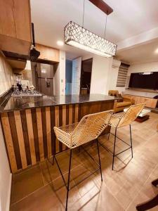 una cocina con 2 sillas y un bar en una habitación en Apto en Ciudad Guabinas - via Cali -Yumbo con piscina y Aires, en Yumbo