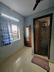 ein leeres Zimmer mit einem Spiegel und einem Fenster in der Unterkunft KENSON HOMESTAY in Mangaluru