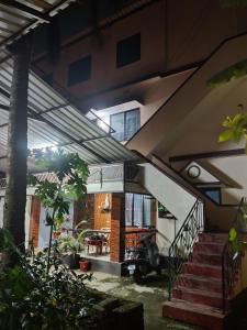 a house with awning and stairs with a scooter in the yard at KENSON HOMESTAY in Mangalore