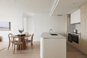 a kitchen with a table and a white counter at Talle by Follo in Newcastle