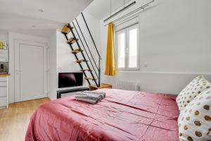 Un dormitorio con una cama roja y una escalera en Studio mezzanine 3-4 pers tout équipé Paris WIFI - R9 en Montreuil
