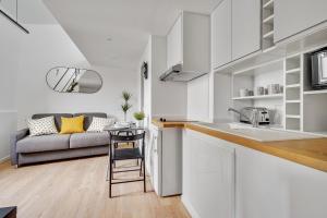 cocina y sala de estar con sofá en Studio mezzanine 3-4 pers tout équipé Paris WIFI - R9 en Montreuil