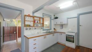 a kitchen with white cabinets and a sink at Koala Lodge Unit 4 in Iluka