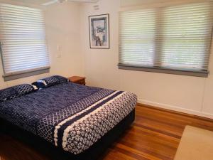 a bedroom with a bed and two windows at Koala Lodge Unit 4 in Iluka
