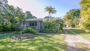 an exterior view of a house with palm trees at Koala Lodge Unit 4 in Iluka