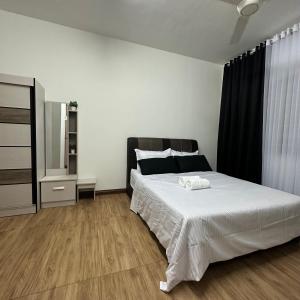 a bedroom with a large white bed and a mirror at The Myrini Homes - Cityview Near Drawbridge in Kuala Terengganu