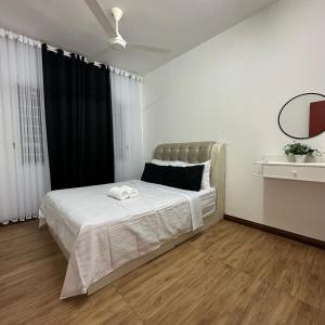 a bedroom with a bed with white sheets and black curtains at The Myrini Homes - Cityview Near Drawbridge in Kuala Terengganu