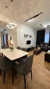 a living room with a table and chairs and a couch at The Myrini Homes - Cityview Near Drawbridge in Kuala Terengganu