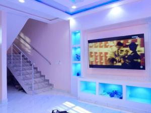 a living room with a tv and a staircase at Porto-Novo Charme Townhouse in Porto-Novo
