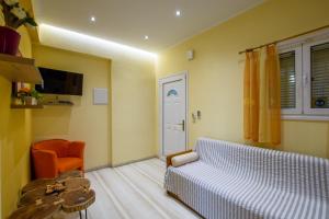 een slaapkamer met een bed, een stoel en een tafel bij Butterfly Appartments in Barbati