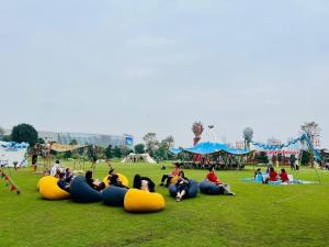a group of people laying on the grass in a park at Homestay Smart - Vinhomes Tu Liem Ha Noi in Hanoi