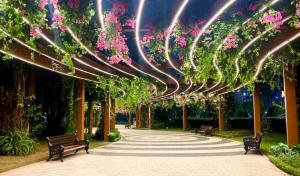 Una pasarela con bancos y flores en un parque en Homestay Smart - Vinhomes Tu Liem Ha Noi, en Hanói