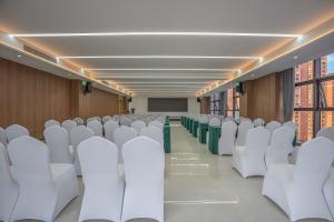 una sala de conferencias con sillas blancas y una mesa en YueSen Yizhi Hotel, en Dazhou