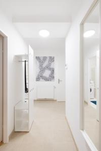 Dieses weiße Zimmer verfügt über einen Flur mit weißen Wänden. in der Unterkunft NEW! ShalalaLiving - Lucky strike! Cozy & Homely near Schönbrunn PG20 in Wien