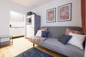 ein Wohnzimmer mit einem Sofa und einer Küche in der Unterkunft NEW! ShalalaLiving - Lucky strike! Cozy & Homely near Schönbrunn PG20 in Wien