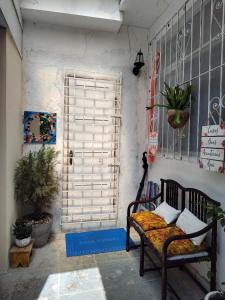 una habitación con un banco frente a una puerta en Suíte próxima ao Porto da Barra, en Salvador