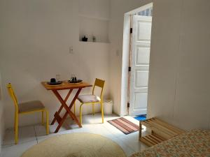 a room with a table and two chairs and a door at Suíte próxima ao Porto da Barra in Salvador