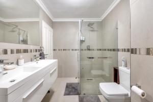 Un baño blanco con ducha y WC. en Oceanview Holiday Accommodation, en Bloubergstrand 33 fotos más