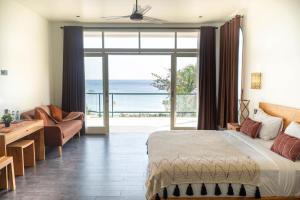 1 dormitorio con cama y vistas al océano en The Cokelat Amed, en Amed