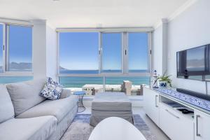 a living room with a couch and a tv at Oceanview Holiday Accommodation in Bloubergstrand