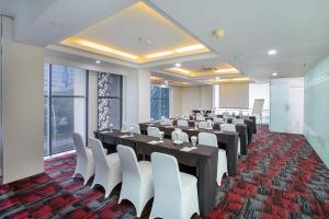 a conference room with long tables and white chairs at 1O1 URBAN Jakarta Thamrin in Jakarta +82 photos