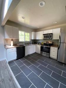 a large kitchen with white cabinets and black appliances at Charming 3 Bedroom home with chimney & RV parking in East Wenatchee