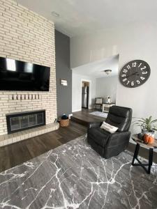 a living room with a black chair and a fireplace at Charming 3 Bedroom home with chimney & RV parking in East Wenatchee